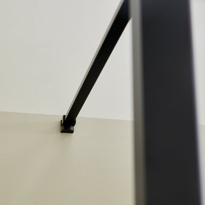 Détail du bras de support noir mat de la paroi de douche à l’italienne
